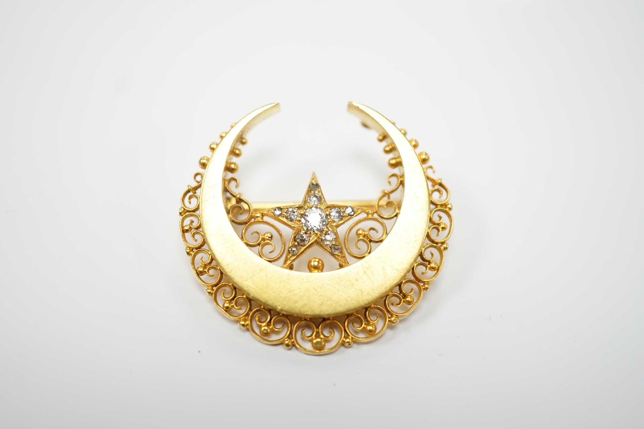 A late Victorian 15ct gold and diamond cluster set crescent and star brooch, 29mm, gross weight 6.8 grams.